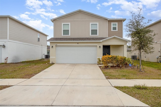 view of property with a garage, a front lawn, and central AC unit