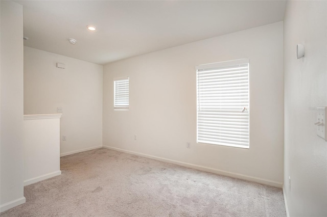 spare room featuring light colored carpet and a wealth of natural light