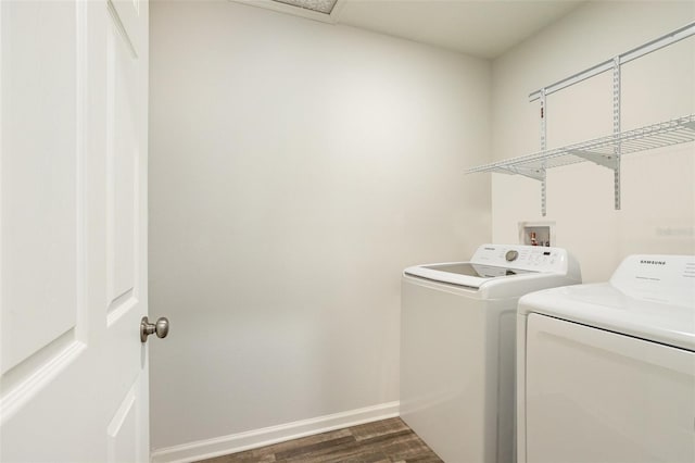 laundry area featuring dark hardwood / wood-style flooring and washing machine and clothes dryer