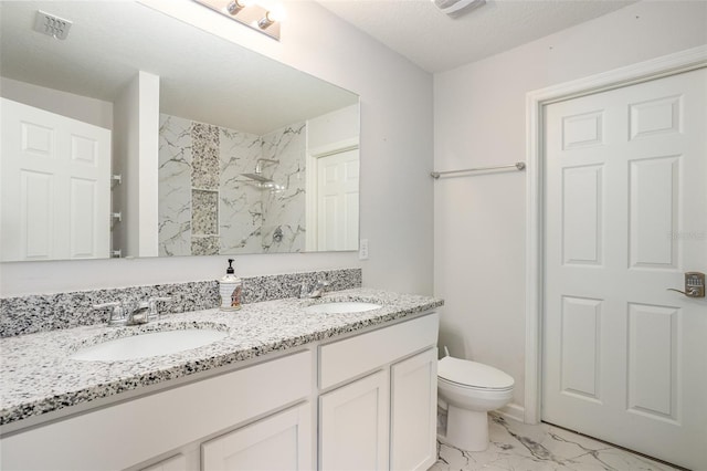 bathroom featuring toilet, a shower, a textured ceiling, and vanity