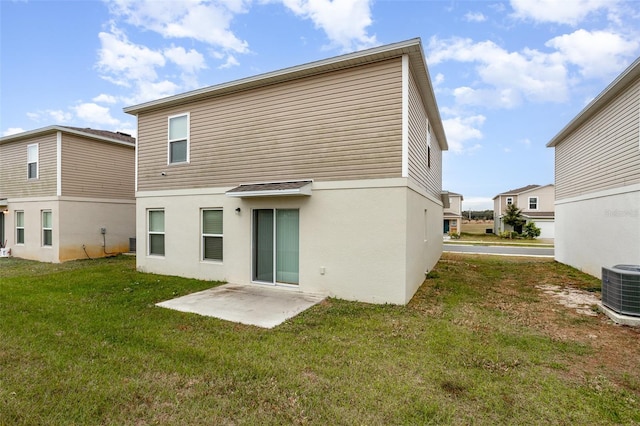 back of property featuring central AC unit, a patio area, and a lawn