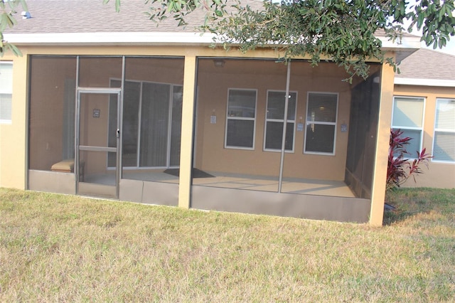 rear view of property with a yard and a sunroom