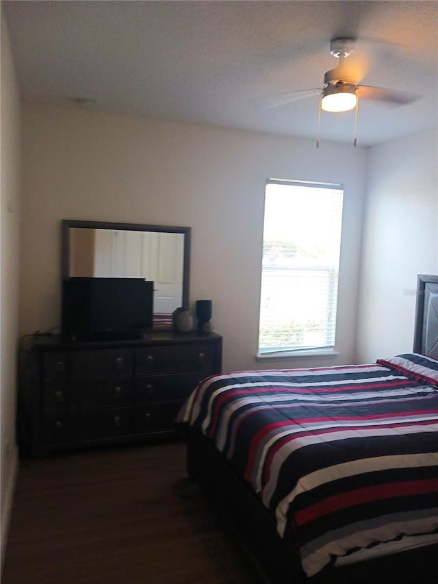 bedroom featuring ceiling fan and dark wood-type flooring