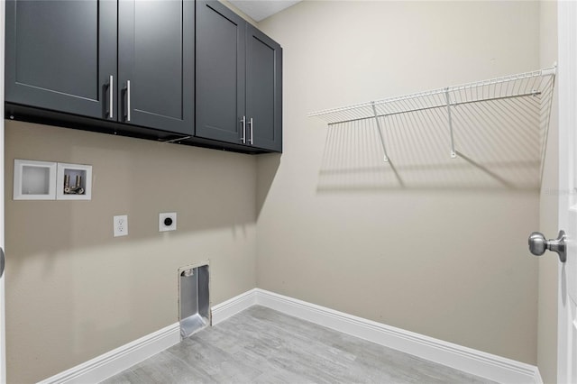 laundry area with hookup for an electric dryer, washer hookup, light wood-type flooring, and cabinets