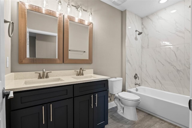 full bathroom with vanity, tiled shower / bath combo, and toilet