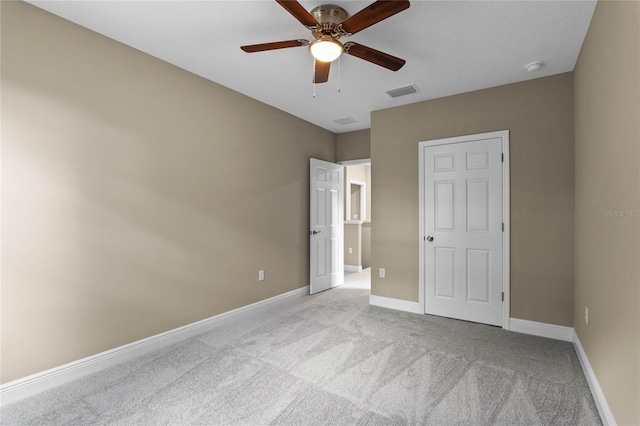 unfurnished bedroom with ceiling fan and light colored carpet