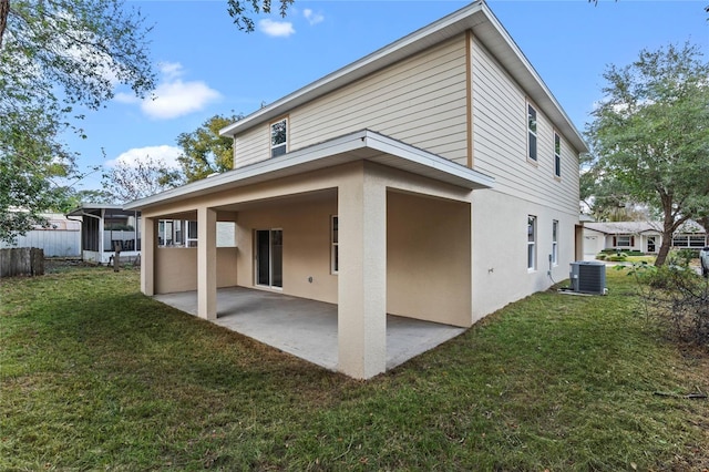 back of property featuring central AC unit, a patio area, and a yard