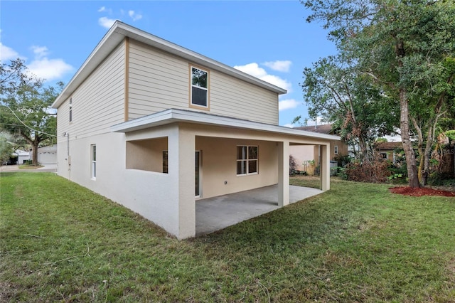 back of house with a patio area and a lawn