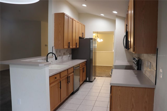 kitchen featuring backsplash, sink, lofted ceiling, and stainless steel appliances