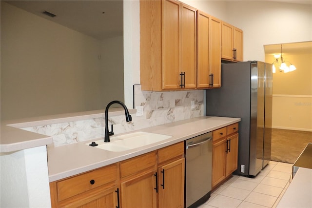 kitchen with pendant lighting, sink, a notable chandelier, light tile patterned flooring, and stainless steel appliances