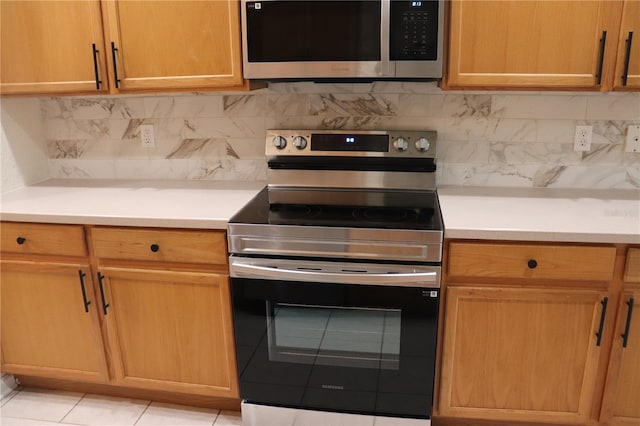 kitchen featuring appliances with stainless steel finishes, backsplash, and light tile patterned floors