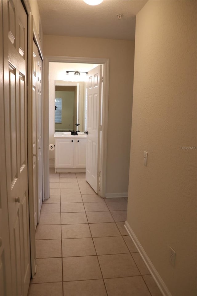 hall with light tile patterned floors