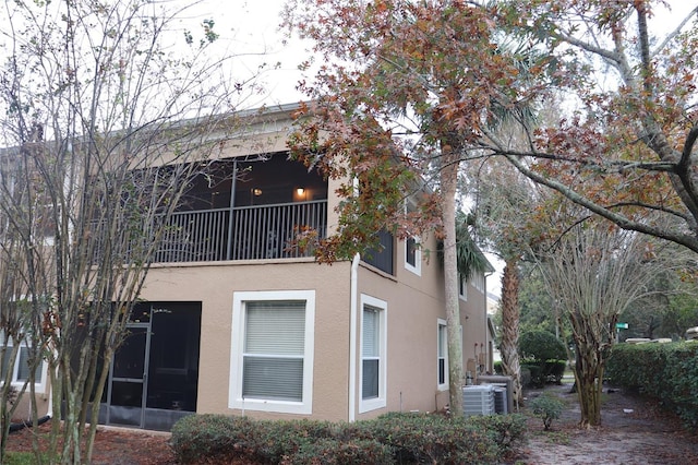 rear view of house featuring a sunroom and central AC unit