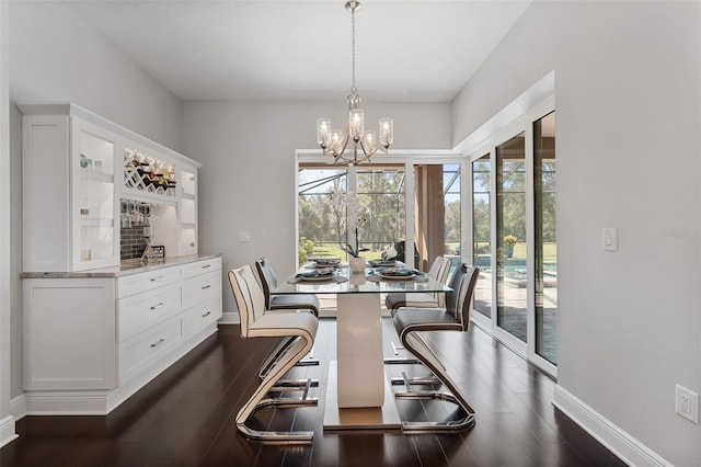 dining space featuring dark hardwood / wood-style floors and an inviting chandelier