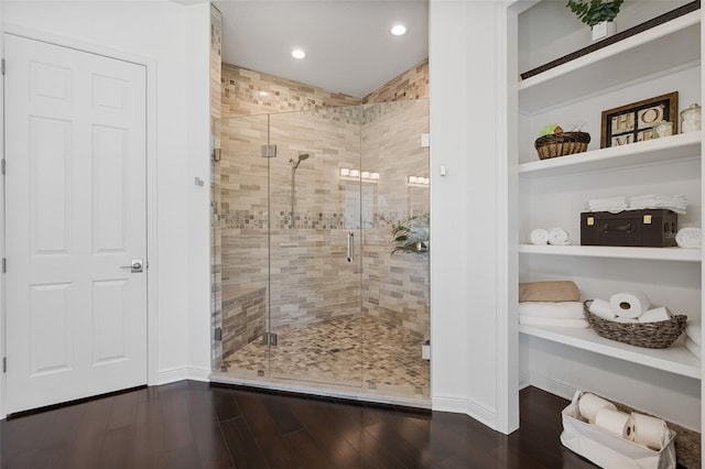 bathroom featuring wood-type flooring and a shower with shower door