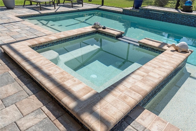 view of pool with an in ground hot tub