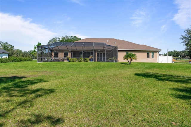 rear view of house featuring a lanai and a yard