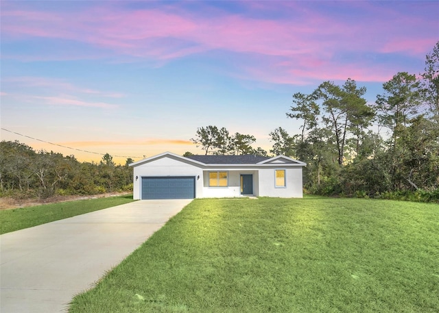 ranch-style house featuring a lawn and a garage