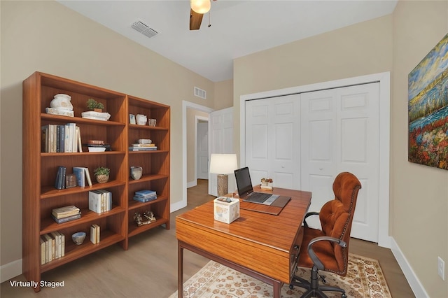 home office with wood-type flooring and ceiling fan