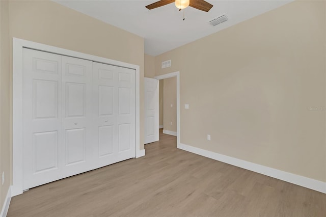 unfurnished bedroom featuring light hardwood / wood-style flooring, ceiling fan, and a closet