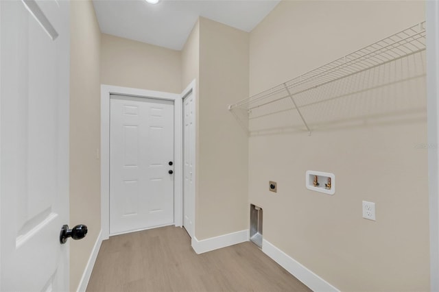 washroom featuring electric dryer hookup, hookup for a washing machine, and light hardwood / wood-style flooring