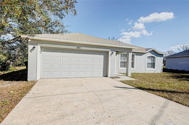 ranch-style house featuring a garage and a front lawn