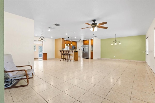 tiled living room featuring ceiling fan with notable chandelier