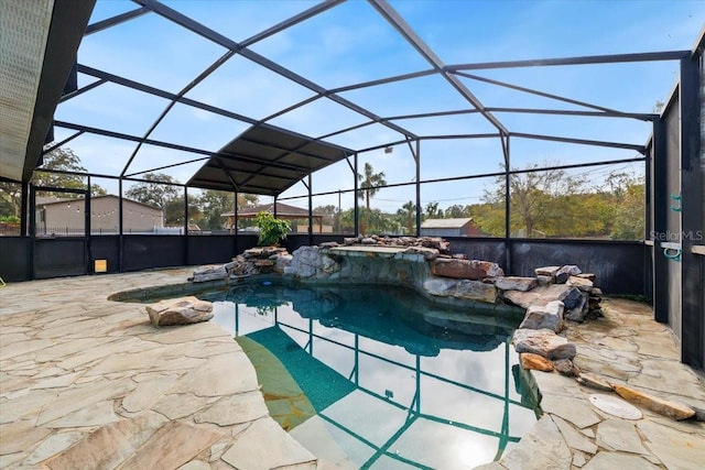 view of pool with glass enclosure and a patio