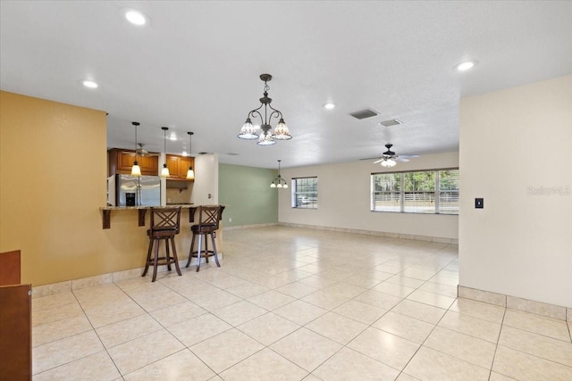 interior space featuring ceiling fan with notable chandelier and light tile patterned floors