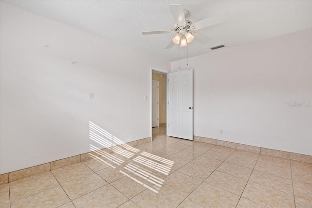 tiled spare room featuring ceiling fan