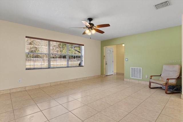 tiled spare room with ceiling fan