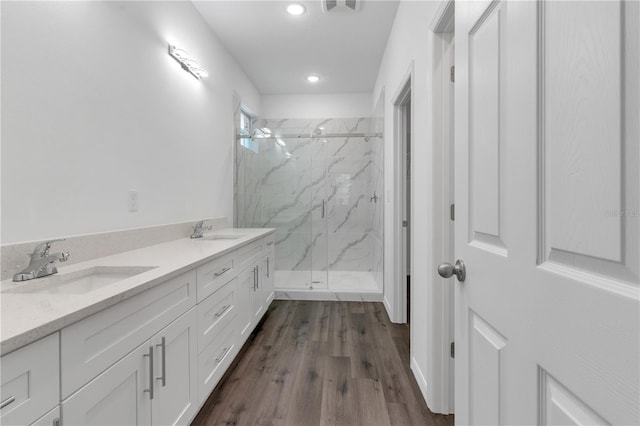 bathroom with walk in shower, vanity, and hardwood / wood-style flooring