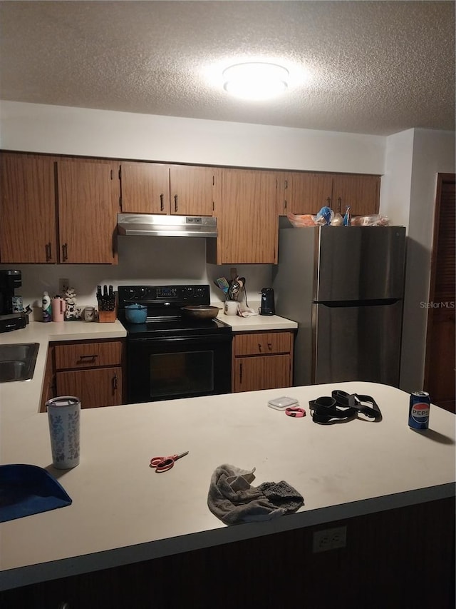 kitchen with electric range, sink, a textured ceiling, and stainless steel refrigerator