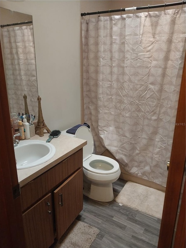 bathroom with vanity, hardwood / wood-style flooring, and toilet