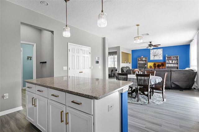 kitchen with a textured ceiling, light hardwood / wood-style floors, white cabinetry, and ceiling fan