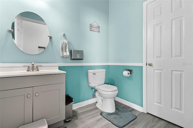 bathroom featuring vanity, hardwood / wood-style flooring, and toilet