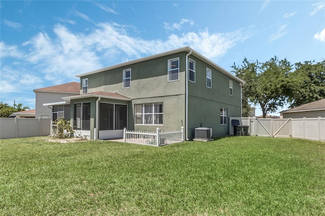 rear view of house with central air condition unit, a sunroom, and a yard