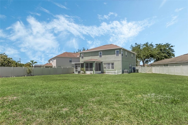 back of house featuring a lawn, central air condition unit, and a sunroom