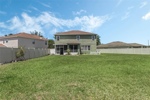 rear view of property featuring a yard