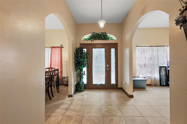 tiled foyer featuring a towering ceiling