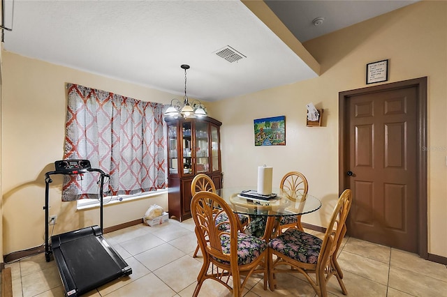 tiled dining room with an inviting chandelier