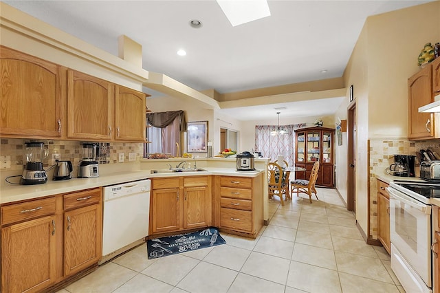 kitchen with sink, kitchen peninsula, decorative light fixtures, white appliances, and light tile patterned flooring