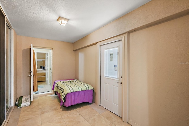 tiled bedroom with a textured ceiling