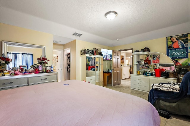 tiled bedroom featuring a textured ceiling