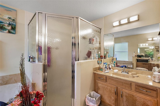 bathroom with a textured ceiling, vanity, and an enclosed shower