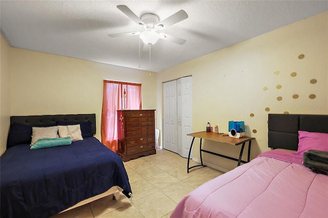 tiled bedroom with ceiling fan, a textured ceiling, and a closet