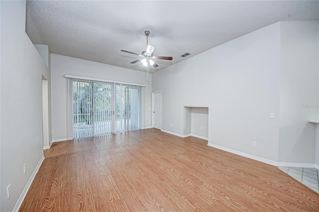 spare room with a textured ceiling, ceiling fan, and light wood-type flooring