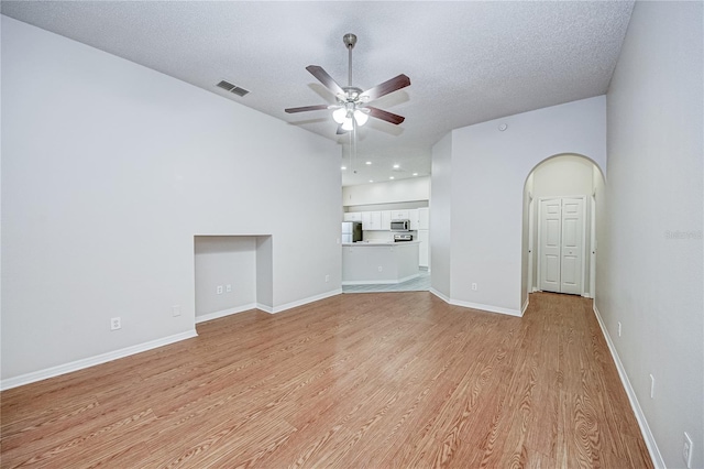 unfurnished living room featuring ceiling fan, a textured ceiling, and light wood-type flooring