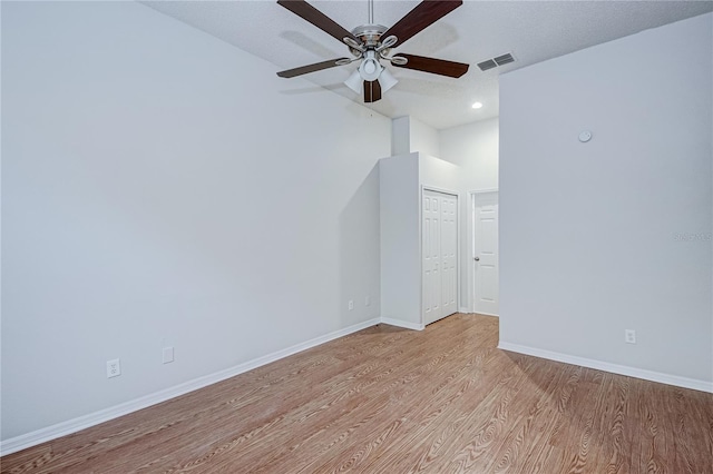 empty room featuring ceiling fan, light hardwood / wood-style flooring, and a textured ceiling