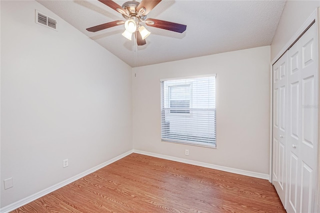 unfurnished bedroom featuring a closet, ceiling fan, a textured ceiling, and light hardwood / wood-style flooring